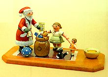 Hubrig, Figuren Kinderbescherung, 106h0004 als Bestell- und Artikelnummer, Weihnachtsmann beim Geschenke verteilen